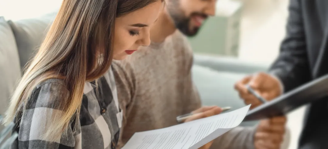 Dos personas leyendo atentamente documentos antes de firmar